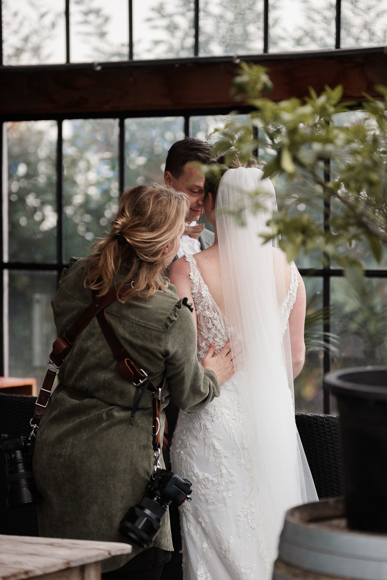 Bruidsfotograaf in actie met bruidspaar tijdens de fotoshoot.