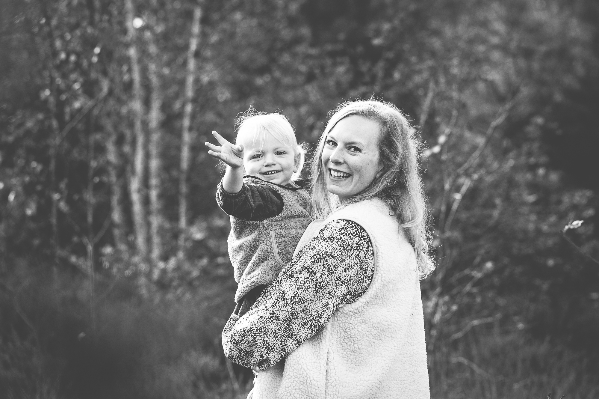 Moeder en dochter die zwaaien naar de fotograaf.