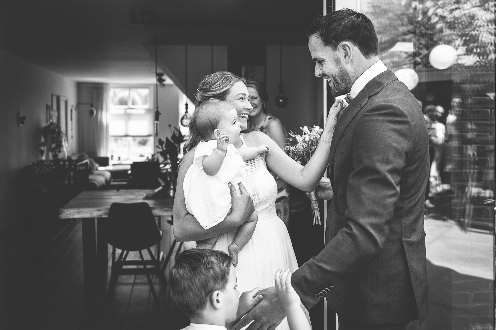 Een man en vrouw samen met hun kleine kinderen, tijdens hun first look op hun bruiloft.