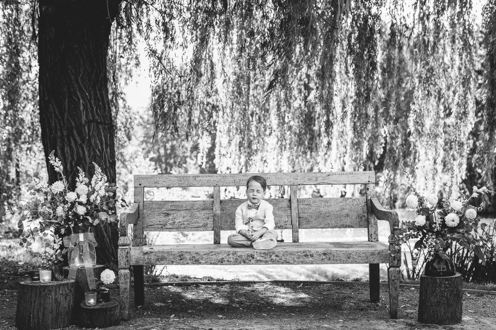bruidsjongen zit stil op een bankje en lijkt te bidden voor de ceremonie