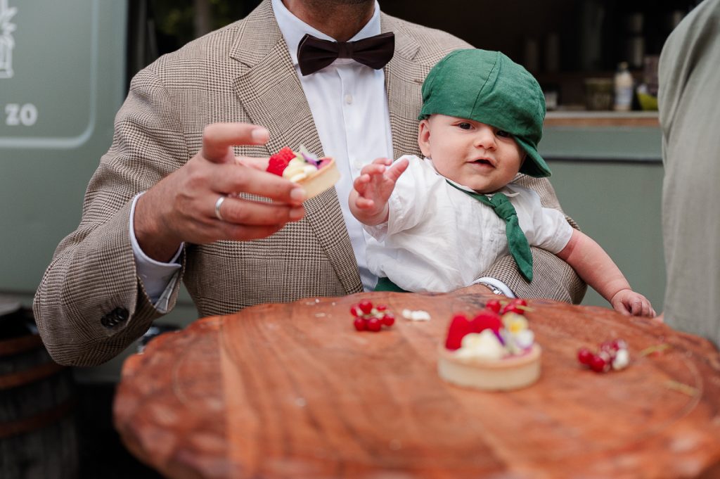 Baby reikt naar taartje tijdens een bruiloft