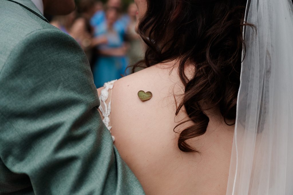 hartjes confetti om een schouder van een bruid.