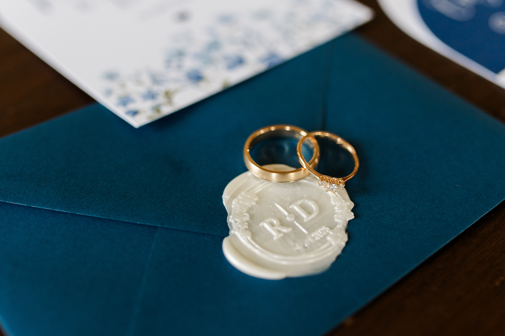 Uitnodiging voor een bruiloft, waarop ringen en een sluit zegel te zien is. 